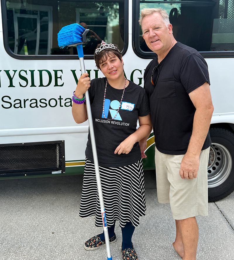 Nicole and Chris beside a Sunnyside Village van with a cleaning brush